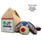A brown takeout-style box sits next to a stuffed dog made from brightly colored reclaimed wool. 