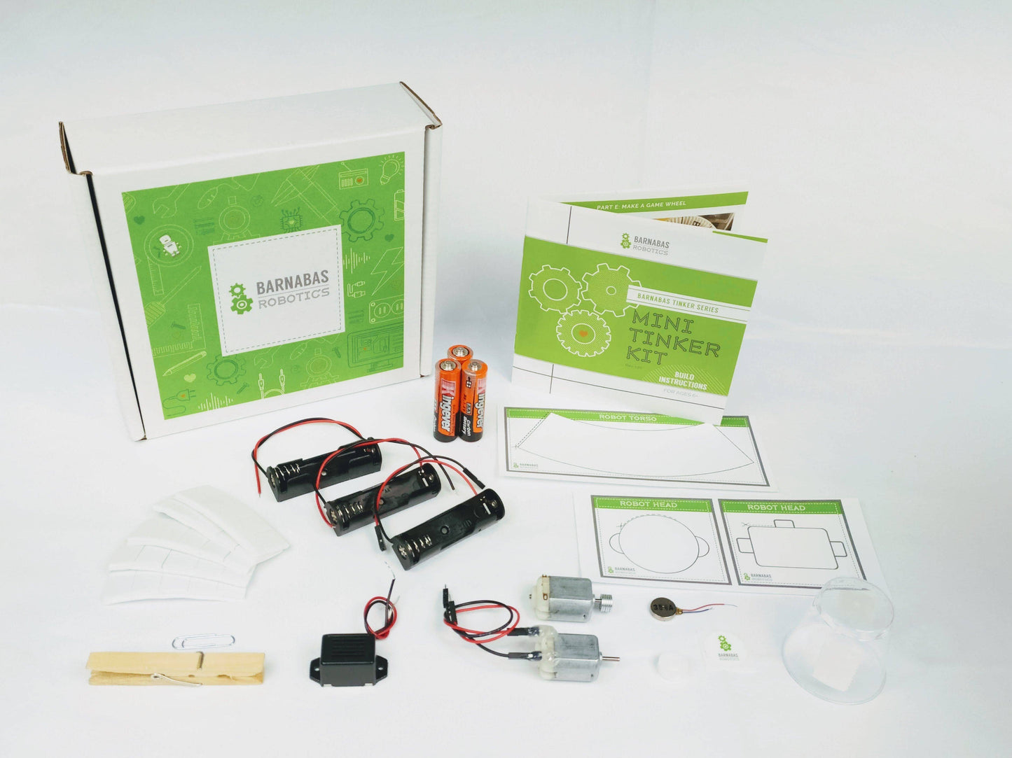 A green box stand upright behind items included to make robot such as batteries, templates, wires, and instructions. 