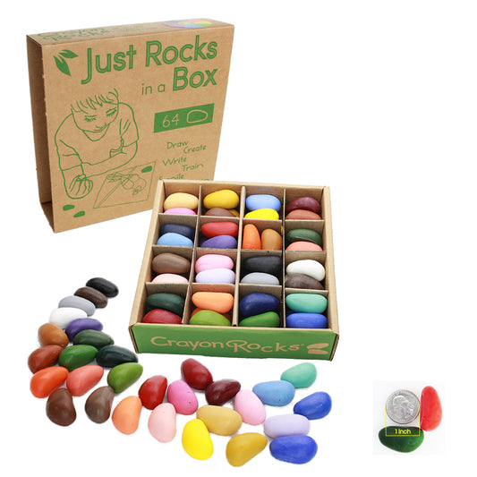 A brown upright box says Just Rocks in a Box, next to it shows the box that goes inside the upright one: divided into 16 squares and holding 64 smooth rock-shaped crayons in many colors. More rocks are spread out along the bottom of the image and a US quarter is shown in the bottom corner next to two crayons, for scale. 